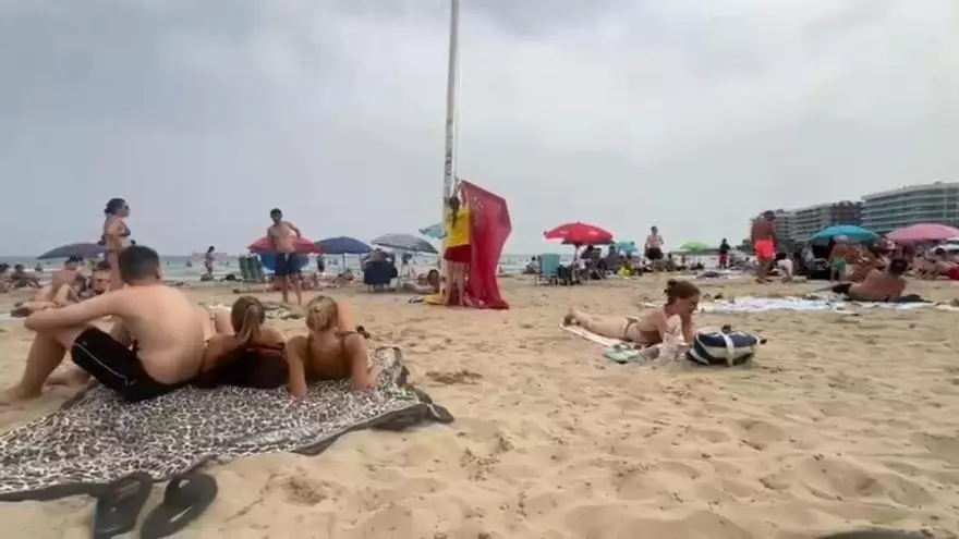 Bandera roja y petición a los bañistas para que salgan del agua y retiren sombrillas en el Postiguet
