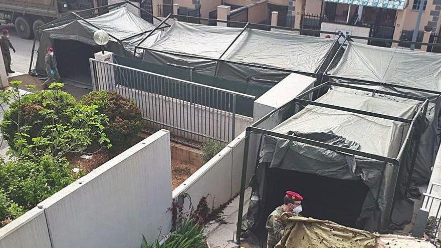 Los militares instalan una carpa que comunica una residencia intervenida en Requena con un centro de día para residentes con Covid-19.