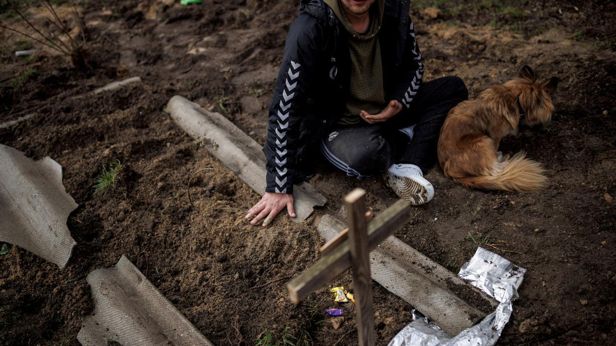 Un ucraniano llora ante la tumba de un compatriota muerto a consecuencia de la invasión rusa.
