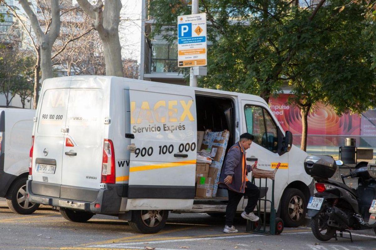 Un repartidor de paquetería baja envíos de su furgoneta en el barrio de Poble Nou de Barcelona. ELISENDA PONS