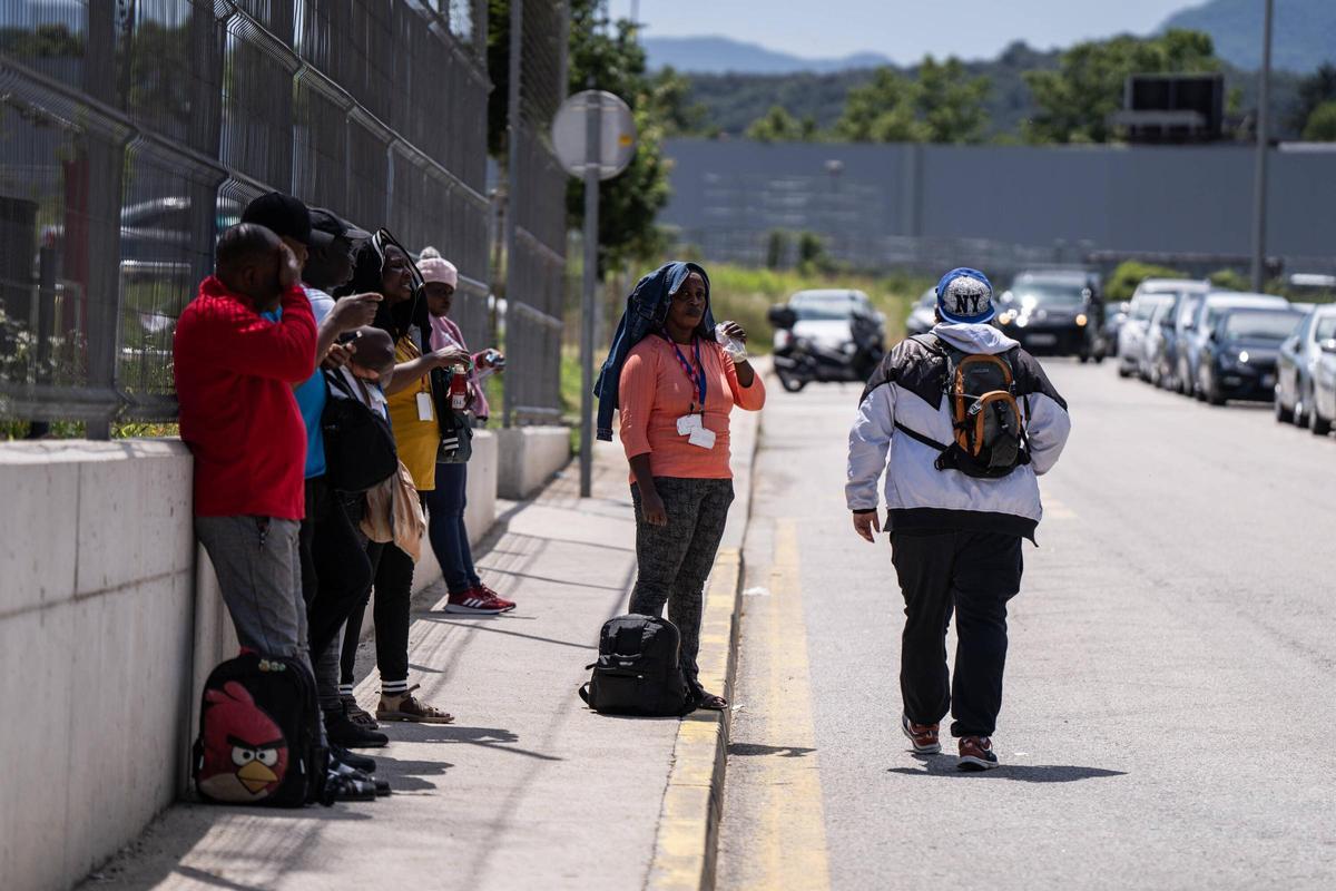 OLOT 09/07/2024 Sociedad. Trabajadores de los mataderos esperando el autobús para volver a sus casas. FOTO de ZOWY VOETEN