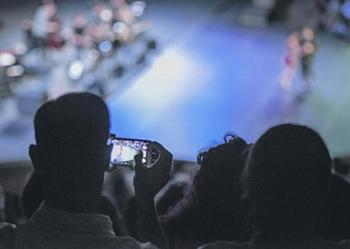 Un espectador haciendo una foto en plena función en el Teatre Grec, el pasado miércoles.