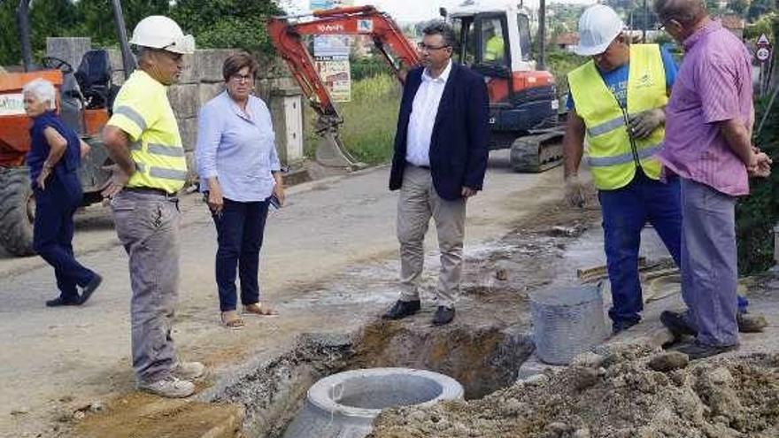 Javier Bas y la edil de Obras, María José Barciela, inspeccionan las obras del saneamiento en la carretera de Padrón, en Saxamonde. // FdV