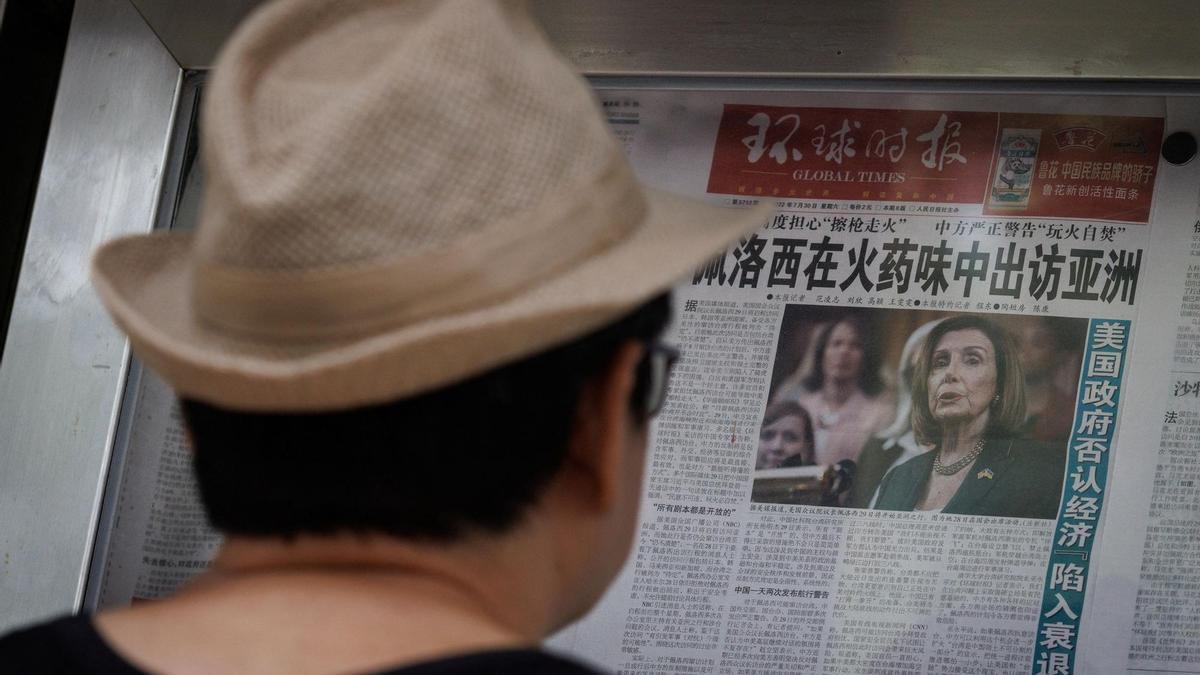 Un ciudadano chino lee un periódico con información sobre la visita de Nancy Pelosi a Taiwán.