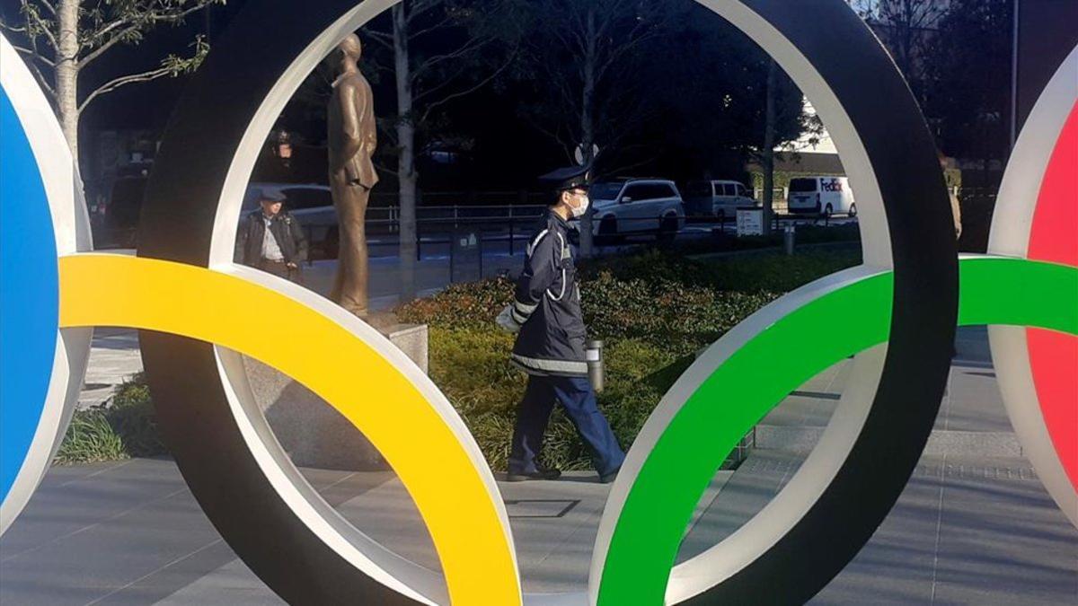 Un policía pasa por delante de los anillos olímpicos en Tokio