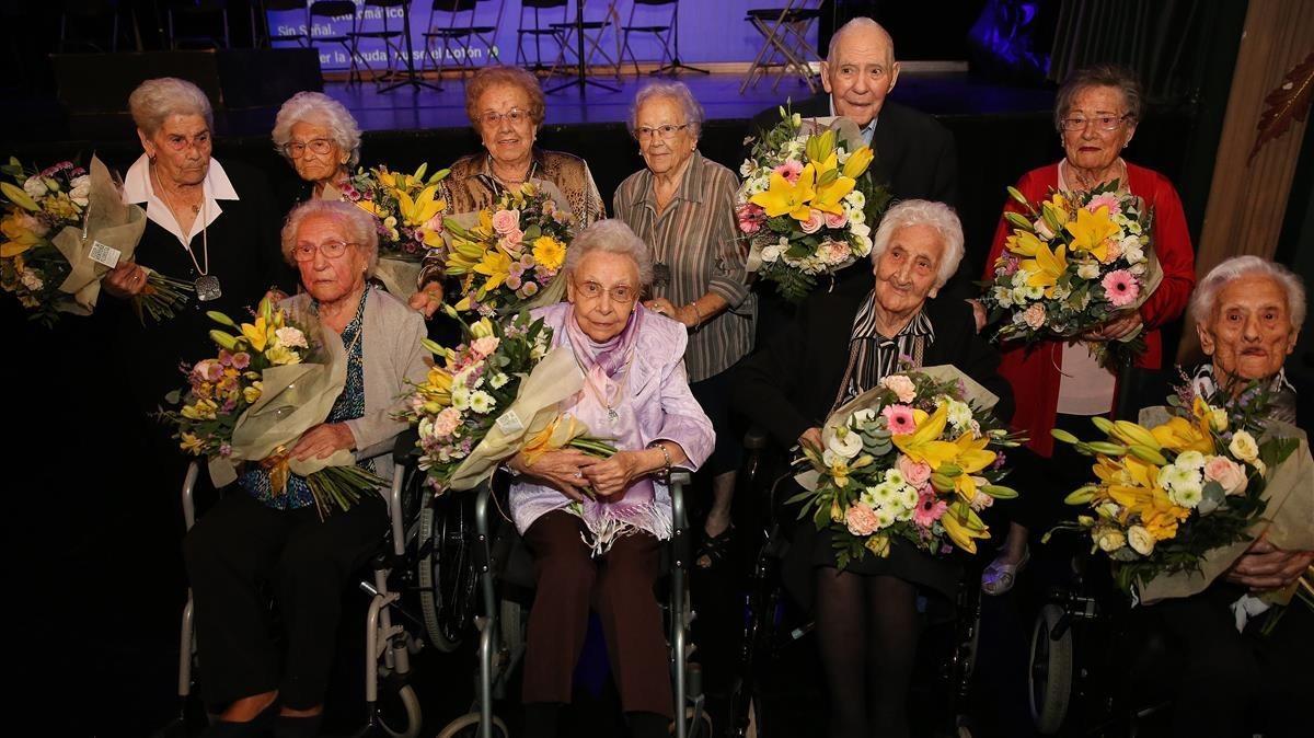 Rafaela Fidelis i Maria Cussó, de peu, quarta i última per l’esquerra, amb altres persones centenàries, al teatre Zorrilla de Badalona, aquest dimecres. 