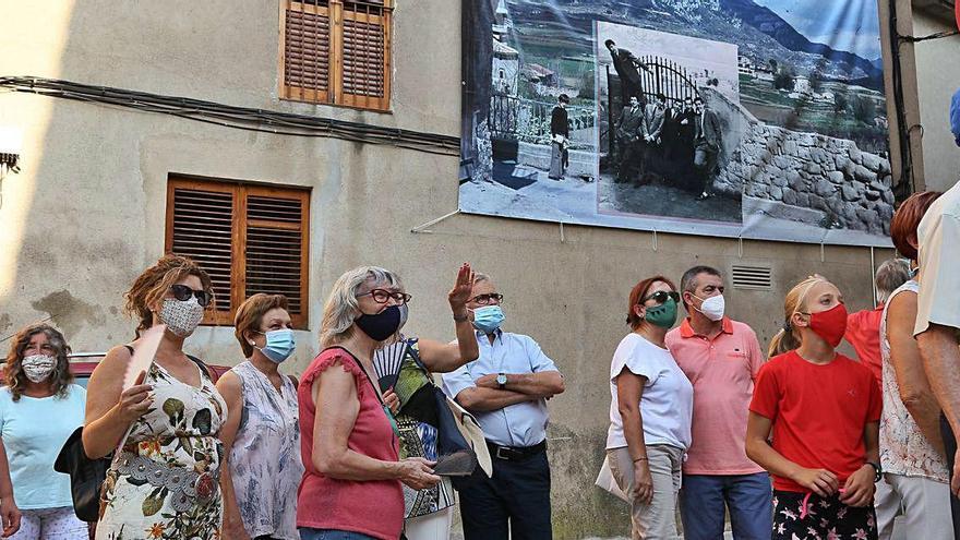 Assistents de la passejada davant d&#039;una de les fotografies de gran format de la mostra, a la placeta Abat Oliba, ahir