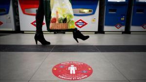 Una pegatina en el suelo en el metro de Madrid invita a mantener la distancia social por el coronavirus.