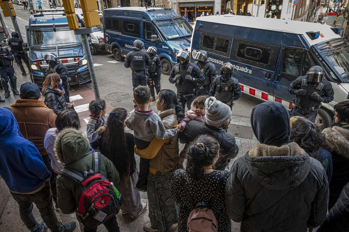 La familia Estefan, aguarda esperando el desalojo de los Mossos d'Esquadra de un banco ocupado donde vivían.