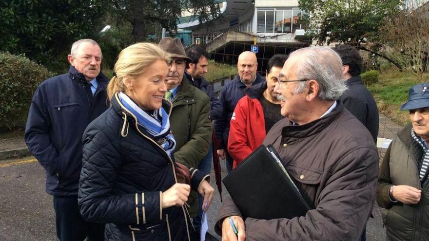 Cristina Coto conversa con Ramón del Fresno y vecinos del Cristo, ayer, ante el viejo HUCA.