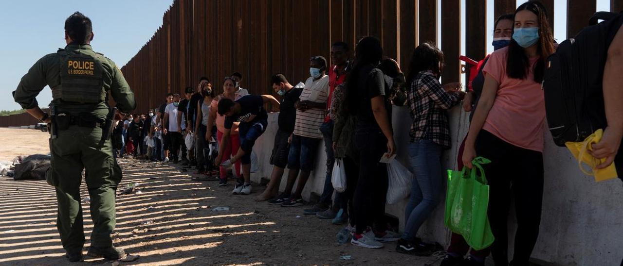 Migrantes solicitantes de asilo, en su mayoría de Cuba y Venezuela, esperan a ser llevados ante la policía de fronteras de EEUU.