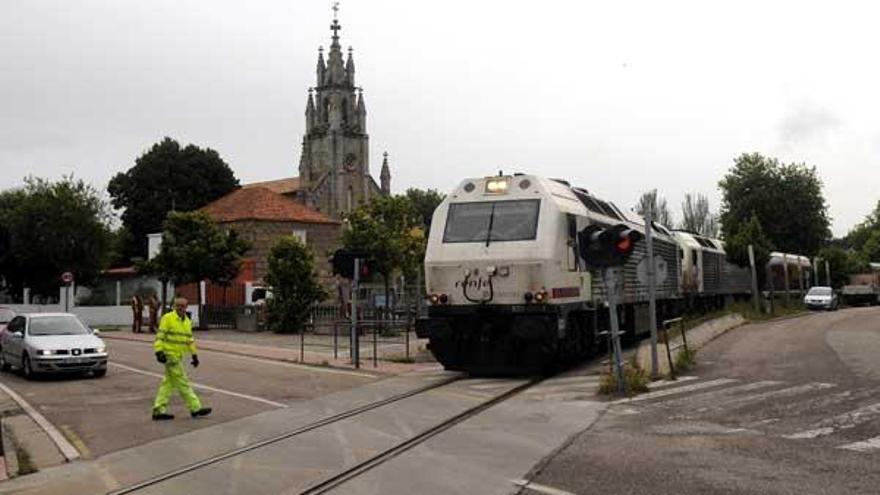 Un tren de mercancías atraviesa la plaza de Placeres en dirección al puerto de Marín este mismo viernes, tras diez años de polémica por este trazado.  // Rafa Vázquez