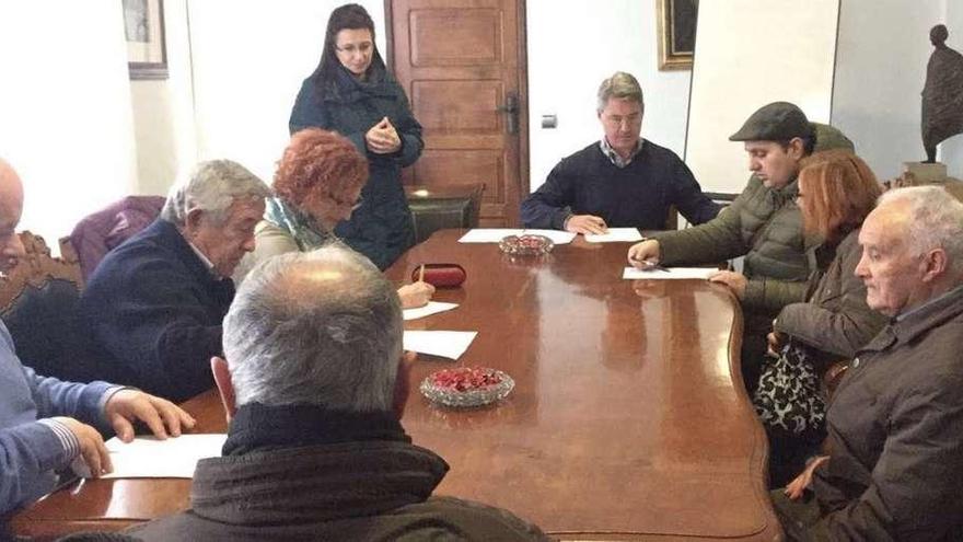 Noemí Outeda (de pie), al lado del alcalde y representantes de las ONG participantes en la firma del convenio. // Muñiz