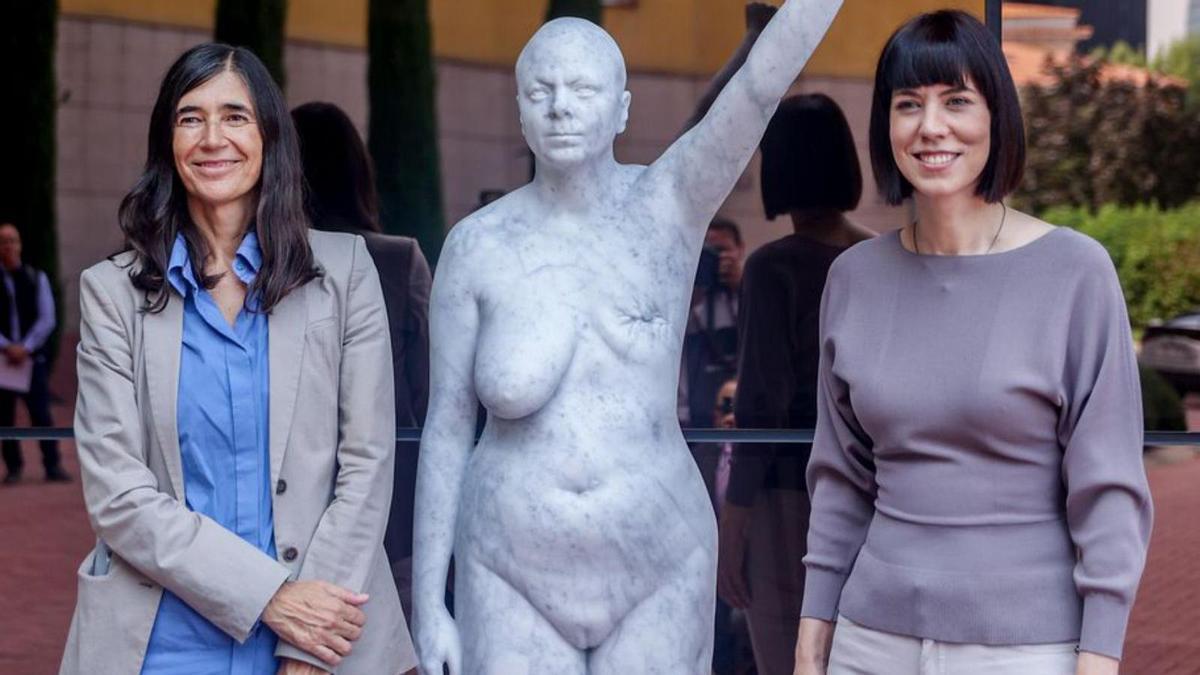 María Blasco (i.) y la ministra de Ciencia, Diana Morant, junto a una escultura a la entrada del CNIO en Madrid, en 2022.