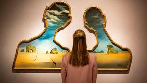 Una mujer, frente al cuadro de Dalí ’Couple aux têtes pleines de nuages’ .