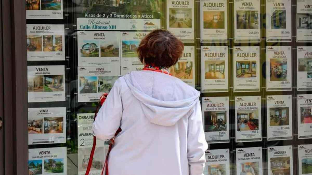 Una mujer observa los anuncios de ventas y alquileres en una inmobiliaria.