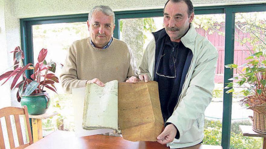 Manuel Uxío y Gerardo Gayo, descubridores del pergamino, con el manuscrito en la mano.  // C. Giménez