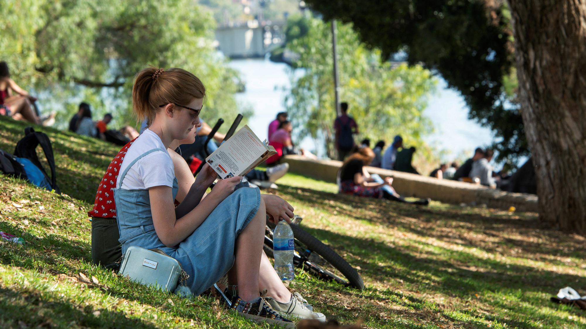 Chica al aire libre en primavera, leyendo en las orillas del Guadalquivir, en Sevilla