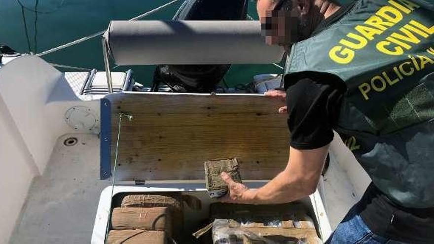 Un guardia civil con parte de la droga decomisada.