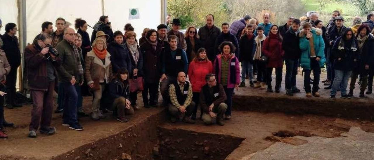Una visita al mosaico, con la Consejera, los arqueólogos y miembros de la asociación entre los asistentes.