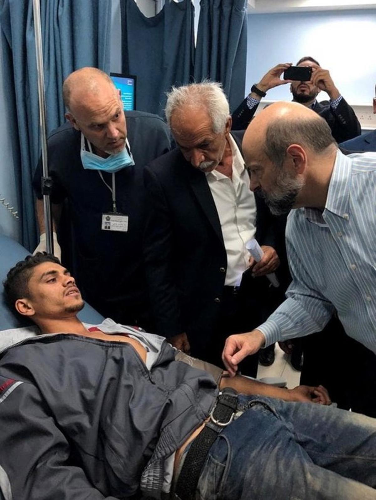 RAI03  AMMAN  JORDANIA   25 10 2018 - Fotografia cedida por la agencia de noticias Petra Jordan  muestra al primer mnistro de Jordania Omar al-Razzaz  d  mientras visita a un herido en un hospital en Amman  Jordania  luego de que un autobus escolar fuera arrastrado por una lluvia torrencial hoy  jueves 25 de octubre de 2018  Segun fuentes de los medios locales  al menos 18 personas  la mayoria de ellas ninos  murieron despues de una lluvia repentina y torrencial que arrastro un autobus escolar que transportaba a los estudiantes que estaban en un viaje cerca del area del Mar Muerto  EFE Agencia de noticias Petra Jordan MEJOR CALIDAD DISPONIBLE SOLO USO EDITORIAL NO VENTAS