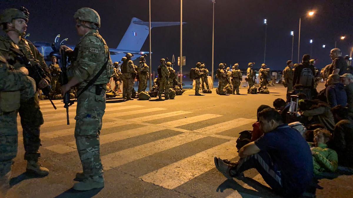 Los soldados franceses montan guardia mientras los ciudadanos franceses y sus colegas afganos esperan ser evacuados.