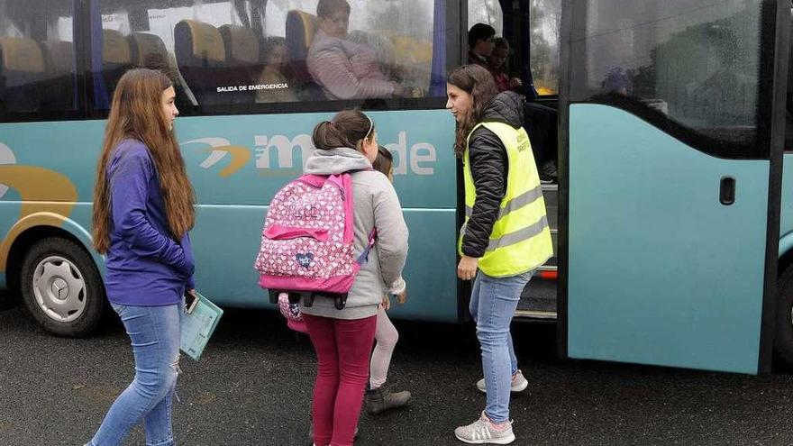 Una usuaria y varios escolares suben a un autobús con destino a Rodeiro. // Bernabé/Javier Lalín
