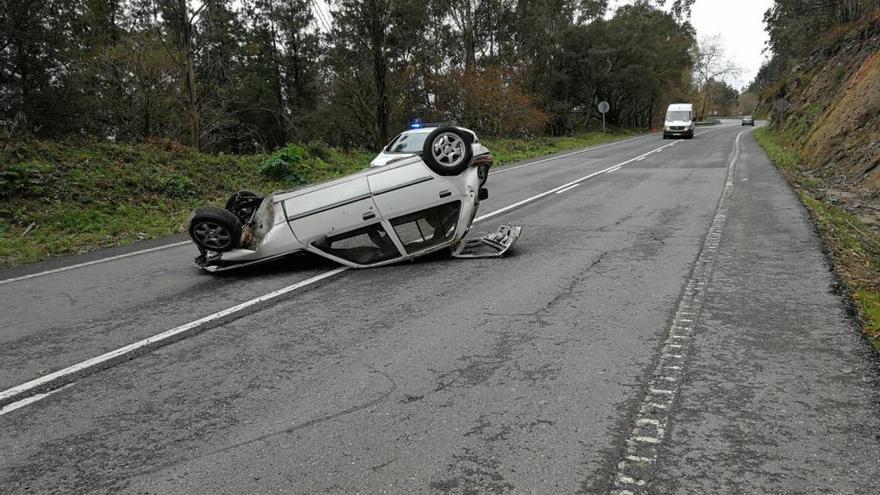 El coche volcado en medio de la calzada. / P.L.