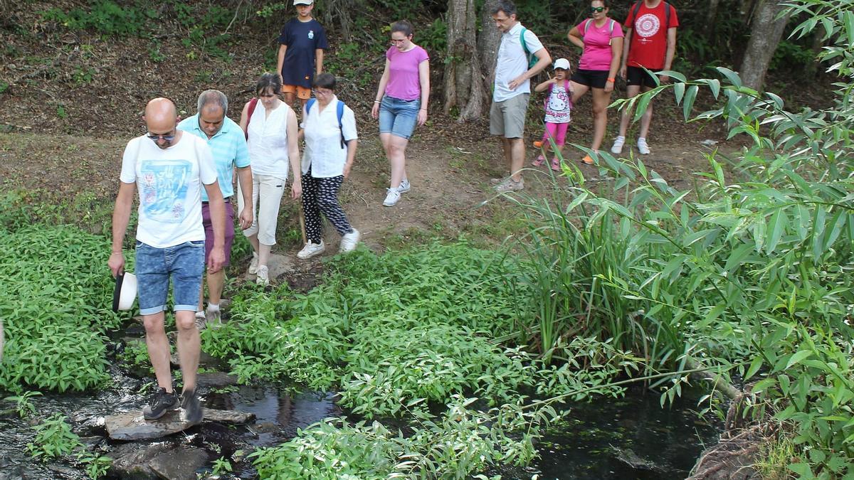 Un grupo de personas recorre la ribera del río Angueira, la Ruta del Contrabando.