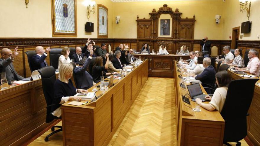 Los ediles de Foro y PP y el concejal no adscrito levantan la mano para aprobar el presupuesto municipales de 2025.