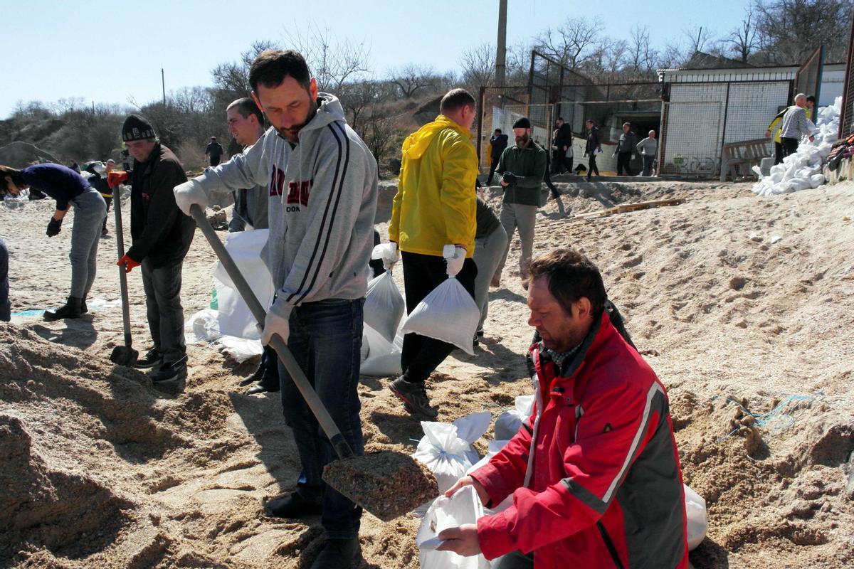 La gente prepara sacos de arena para defender la ciudad, en medio de la invasión rusa de Ucrania, en la costa de Odesa, Ucrania