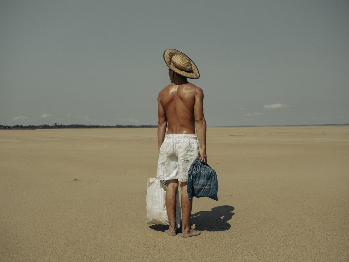 Un joven ayuda a su madre a cargar comida en la Amazonia.