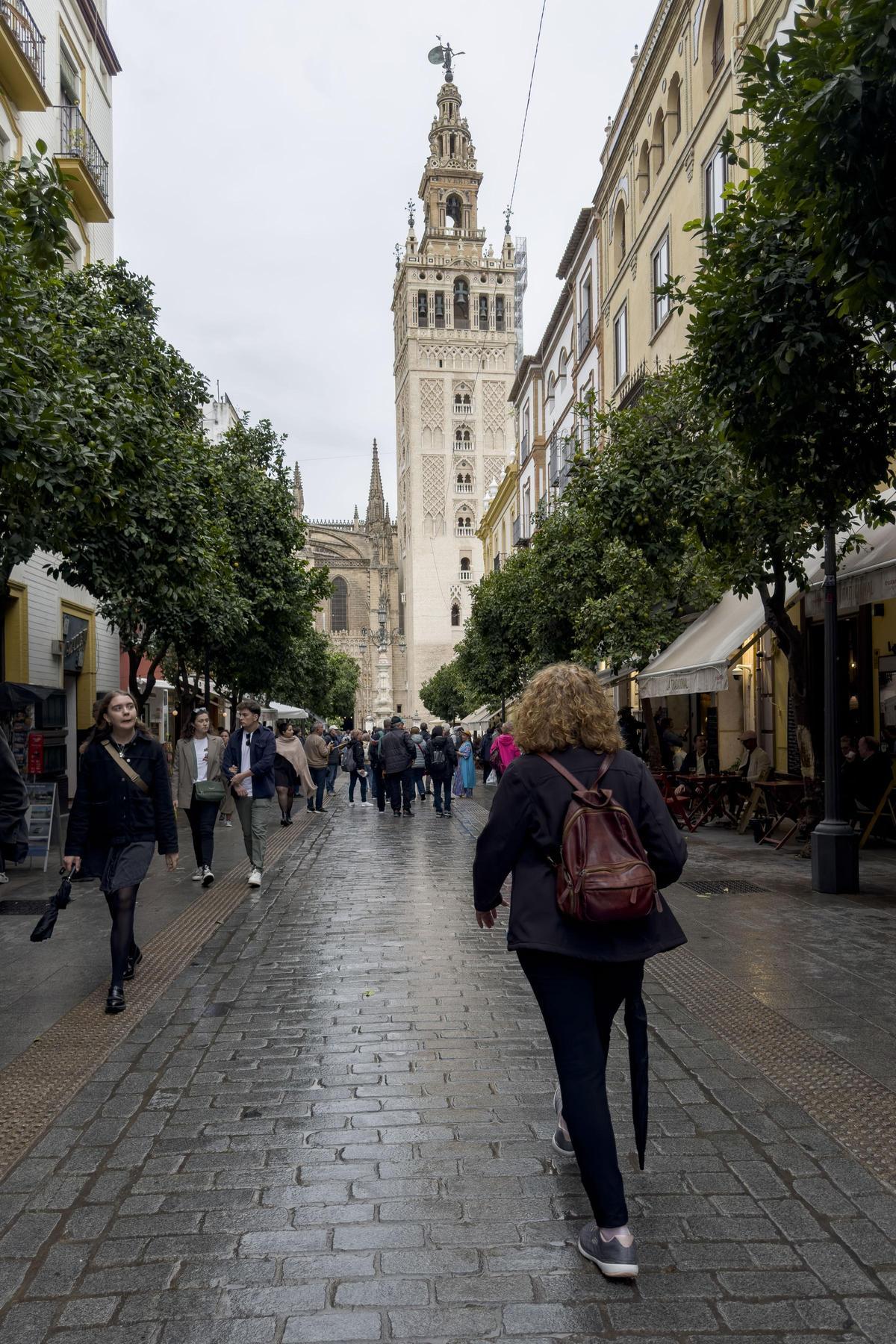 Personas caminan por el centro de Sevilla con paraguas cuando empiezan las primeras lluvias asociadas a la borrasca Bernard.