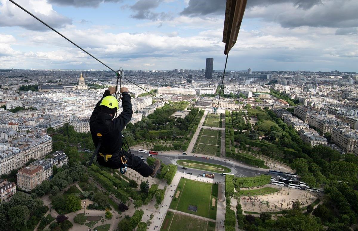 Una persona baja por una tirolina desde el segundo piso de la Torre Eiffel. Los 800 metros llevan un minuto a una velocidad de 90 km. La tirolina se abrirá del 29 de mayo al 2 de junio