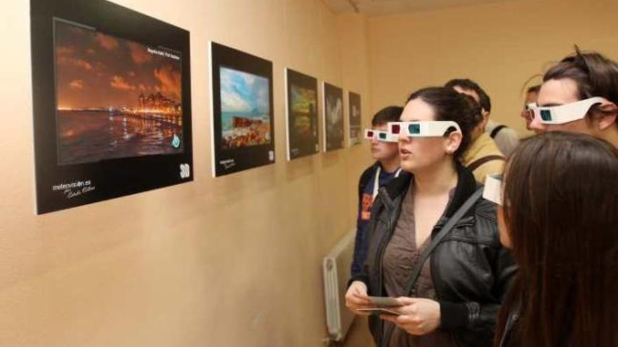 Unos jóvenes observan las imágenes meteorológicas en 3D con las particulares gafas.