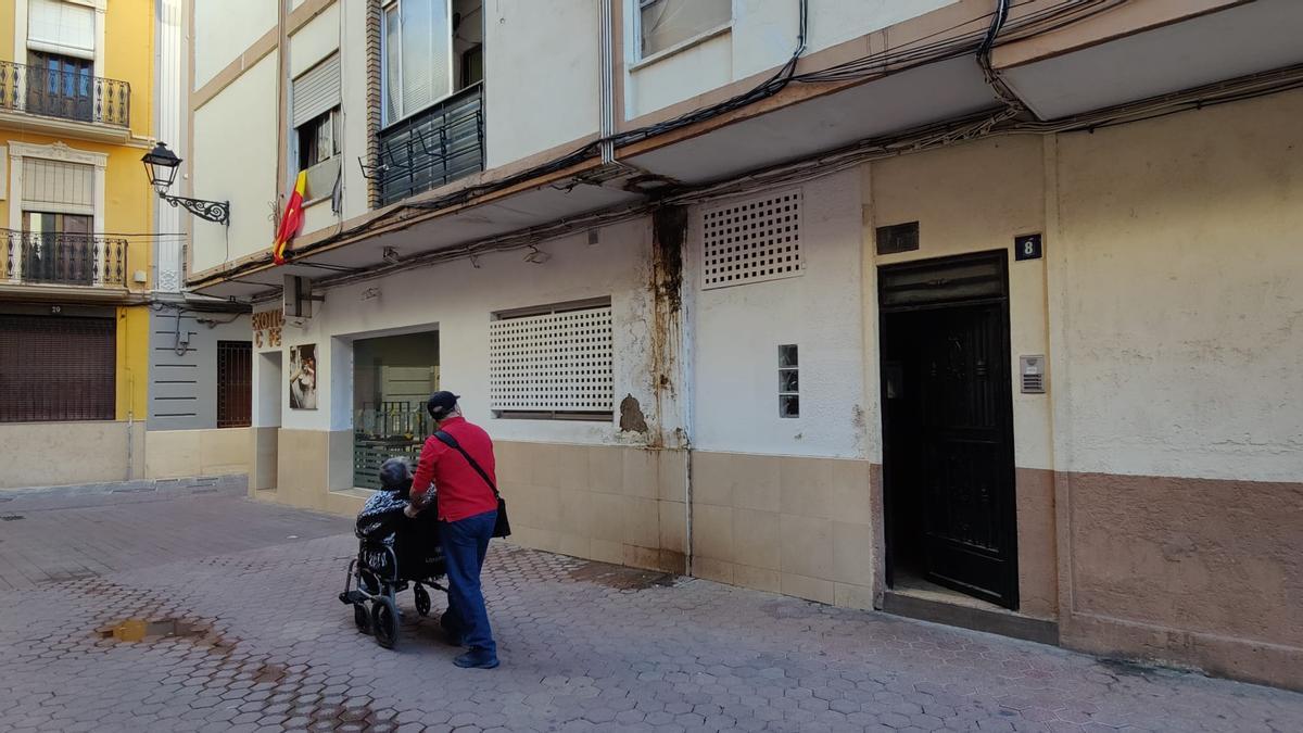 Un vecino de la localidad se fija en los desperfectos en la fachada ocasionados por la fuga de aguas fecales.