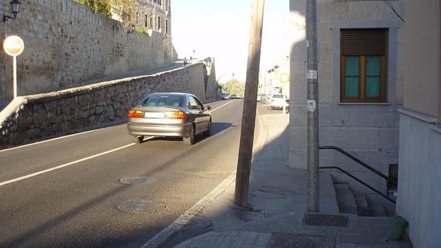 Zona peatonal invadida por un poste de Telefónica y una farola, que obliga a circular por la calzada a personas en silla de ruedas.