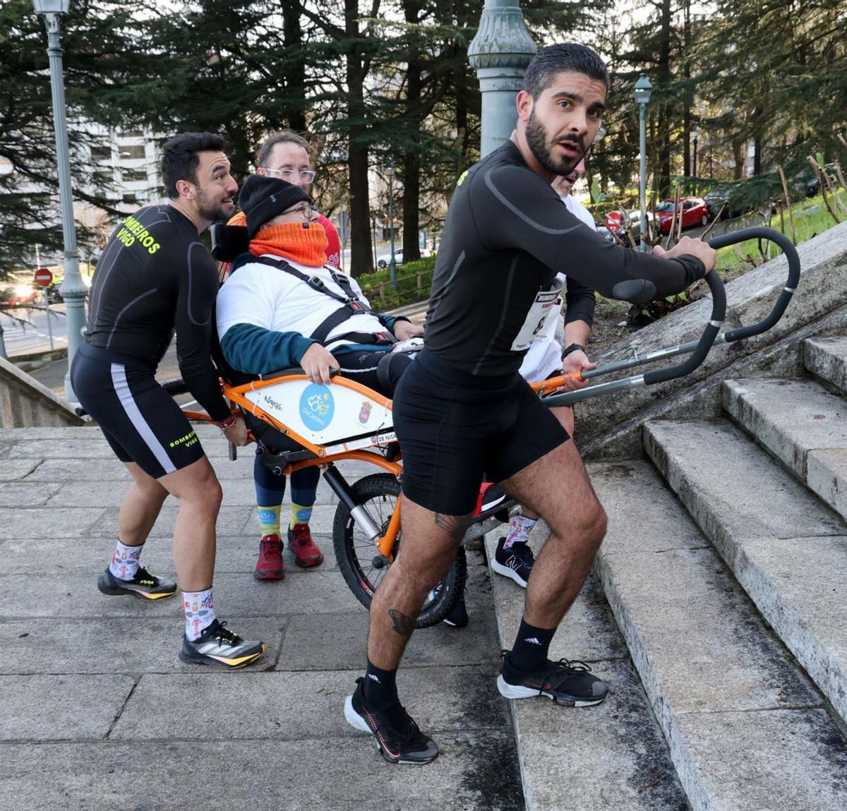 Varios deportistas llevan
a un participante en silla.
| José Lores