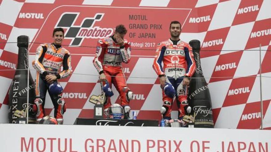 Dovizioso no puede contener la emoción por la victoria, en el podio, junto a Márquez y Petrucci.