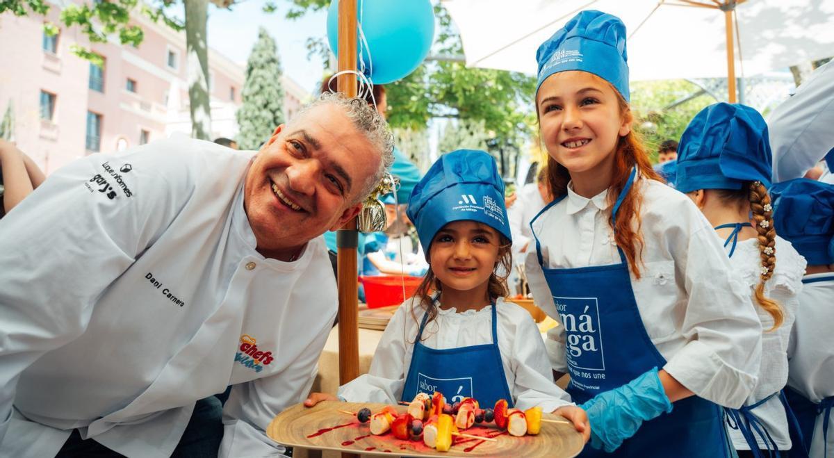 El chef Dani Carnero, con una estrella Michelin, junto a dos menores en un momento del evento solidario.