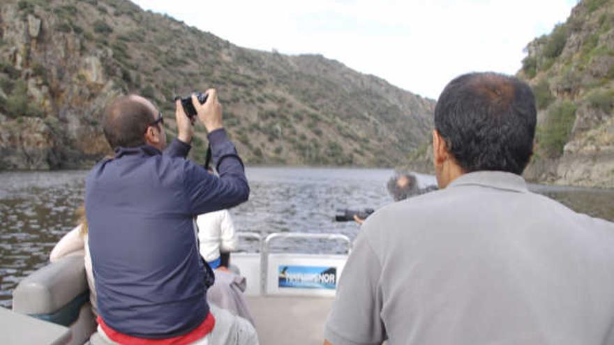 Un turista fotografía los cantiles de Arribes del Duero desde un barco.