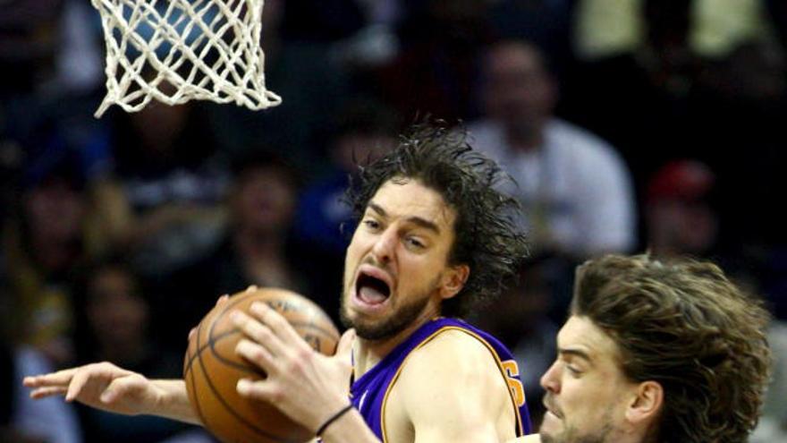 El jugador español de los Grizzlies de Memphis Marc Gasol (d) disputa el balón con Pau Gasol (i) de los Ángeles Lakers, durante el juego de baloncesto de la NBA que enfrenta a ambos equipos en el FedEx Forum de Memphis, Tennessee (EE.UU.). Los Lakers ganaron el juego 115-98.