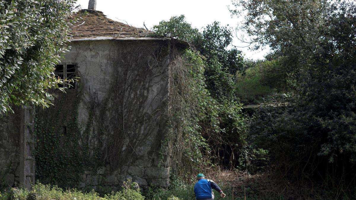 Un hombre trabaja en una aldea del rural lucense