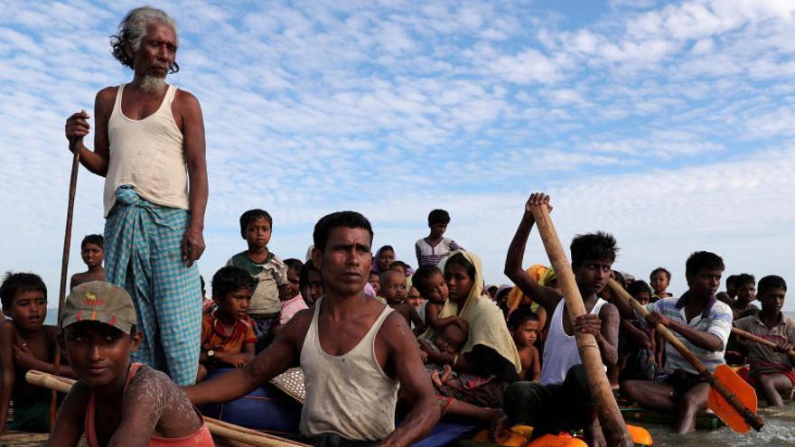 Refugiados rohinyás cruzan un río en una barca improvisada.