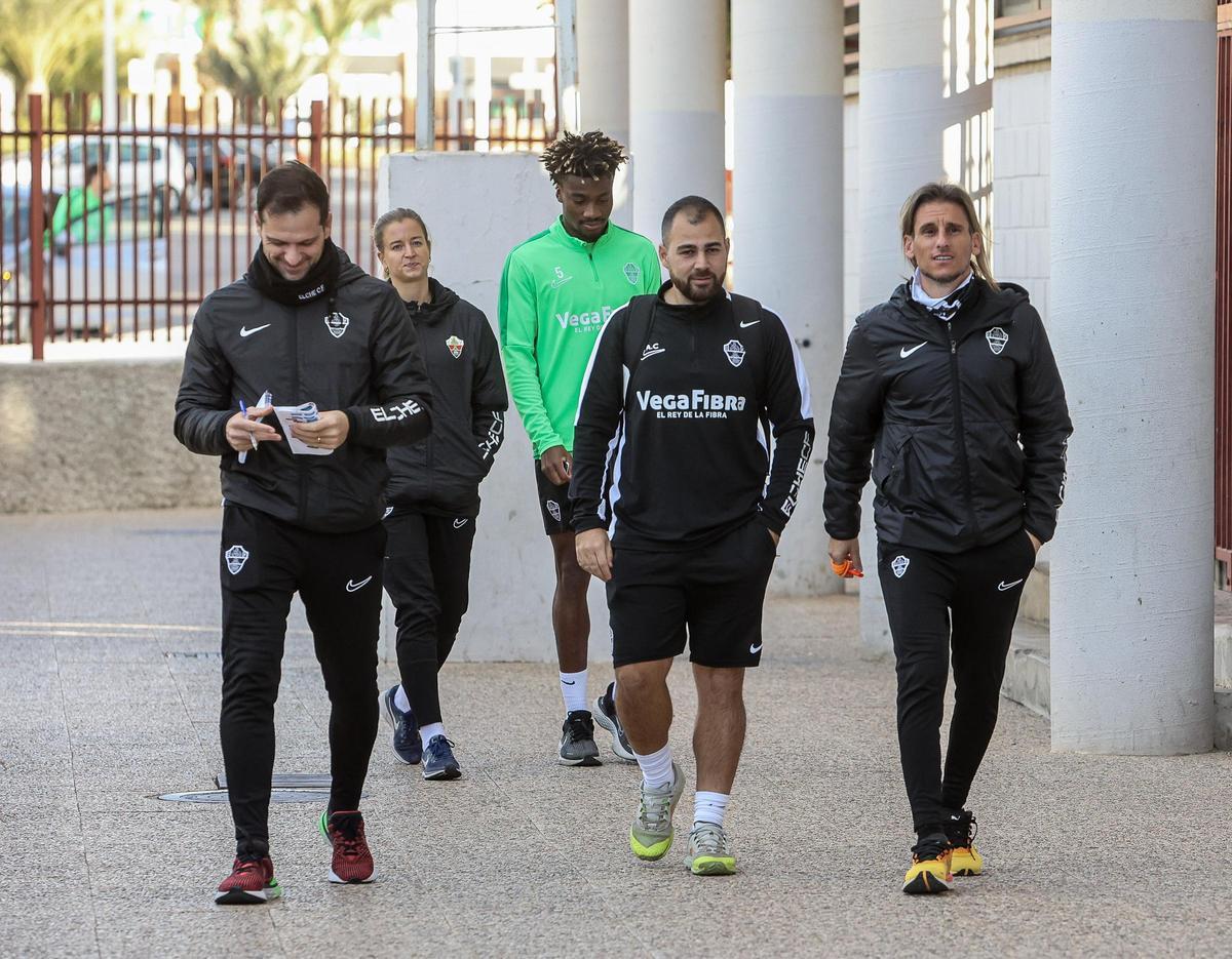 John, al fondo, llega a un entrenamiento junto al cuerpo técnico