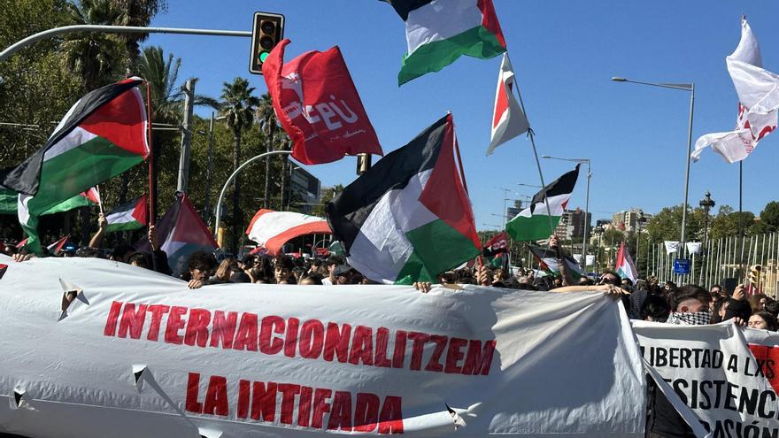 Els manifestants contra el "genocidi" de Palestina a l'avinguda Diagonal es tapen la cara amb les pancartes