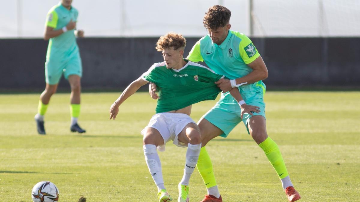 Simo es agarrado por el granadinista Butzke durante el encuentro de este miércoles entre el Recreativo Granada y el Córdoba CF.