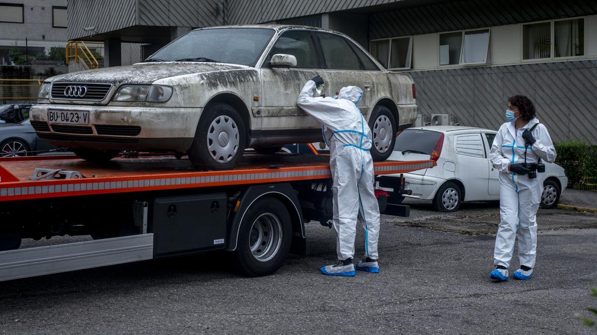 Dos policías, con el coche de la familia Barrio, que lleva en el exterior de la comisaría desde 2007. // BRAIS LORENZO