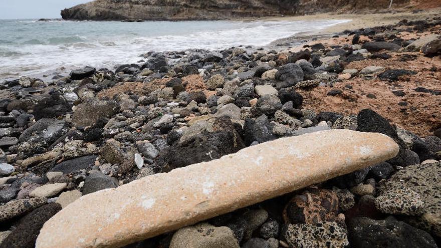 Una de las piezas tiradas entre las piedras de la playa de Tufia.