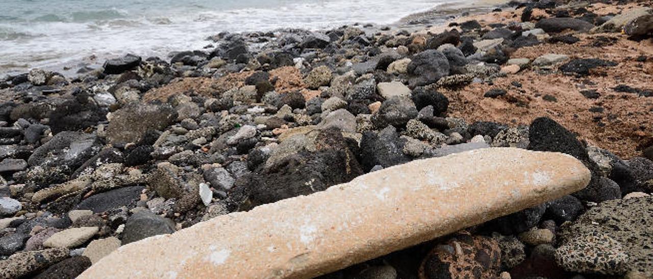 Una de las piezas tiradas entre las piedras de la playa de Tufia.